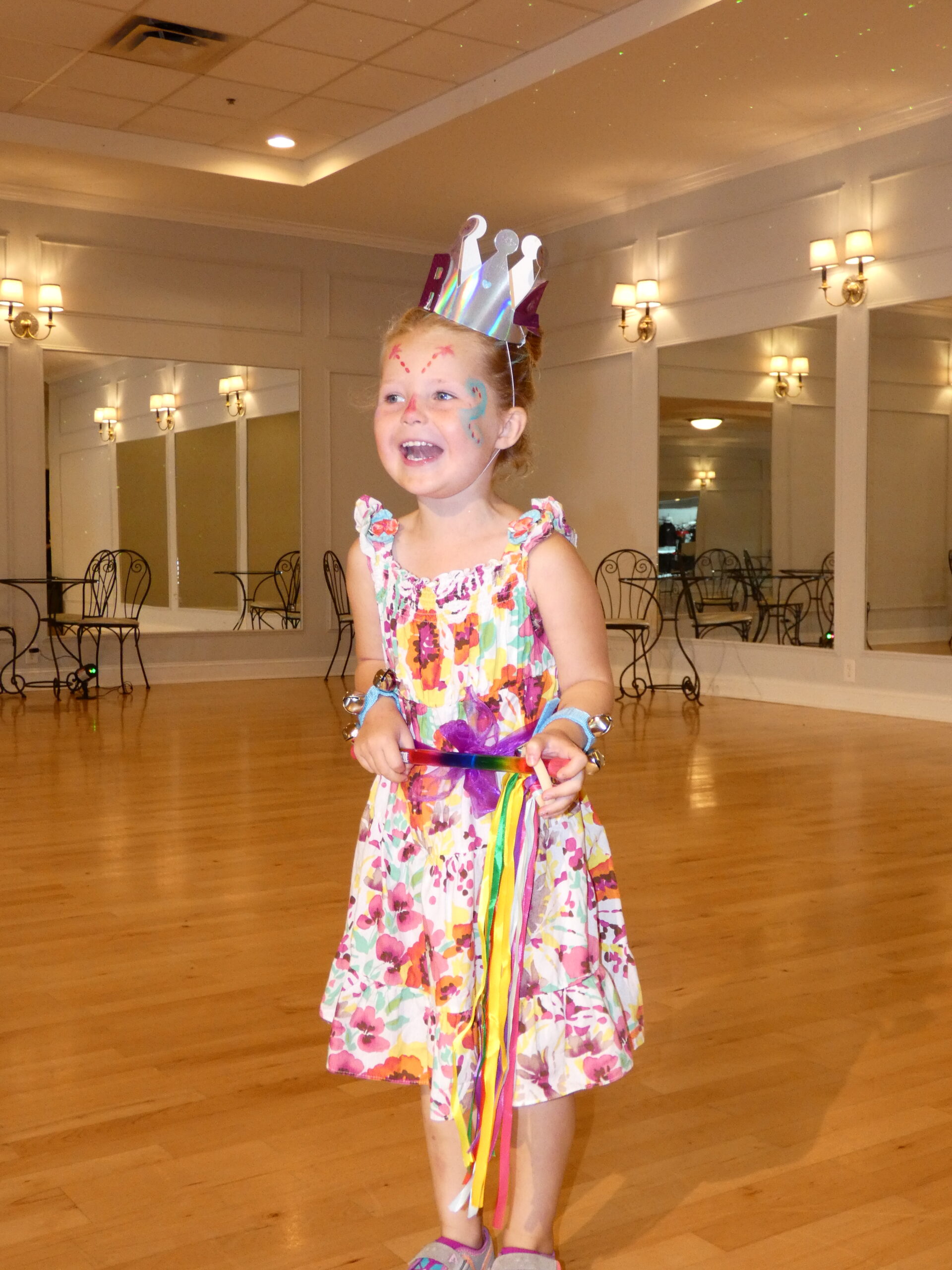 A young camper proudly posing in a handmade crown at QC Dance summer camp, showcasing creativity and confidence.