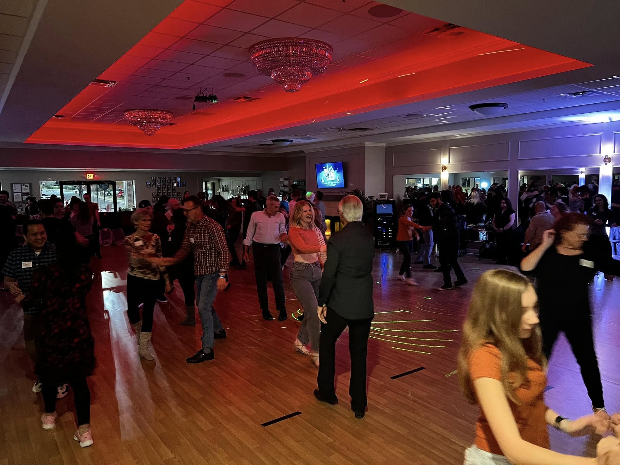 Dancers enjoying a lively West Coast Swing party at QC Dance, hosted by Charlotte Westies, with smooth moves and musicality on display.