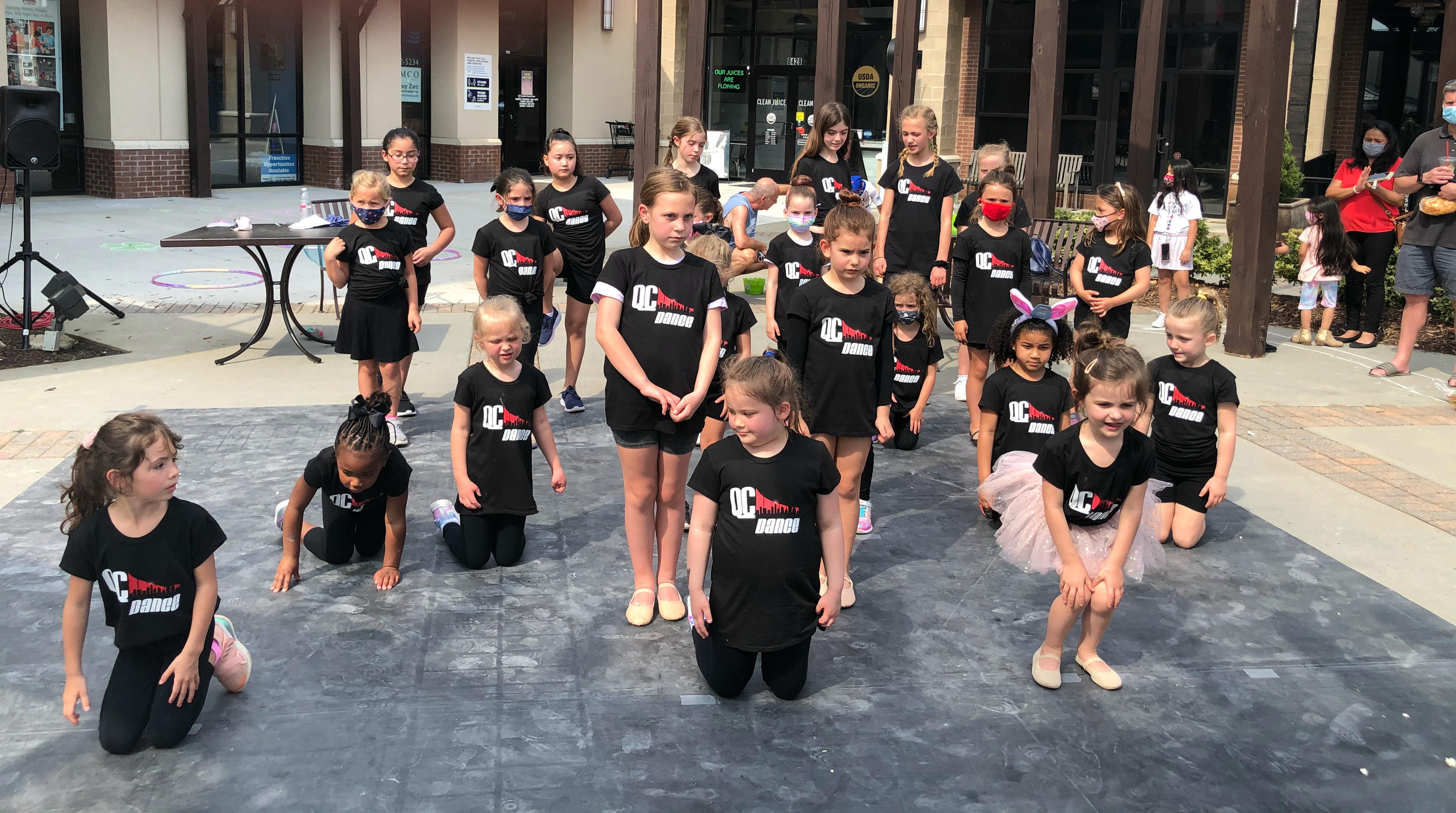 Children smiling and dancing during a summer dance class at QC Dance in Charlotte, NC.